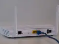 Router bianco con antenne, cavo blu collegato. Soluzione per internet a casa senza fibra.