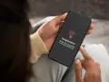 Mani che tengono uno smartphone con un messaggio di avviso "Temperatura". È ora di capire come raffreddare il telefono.