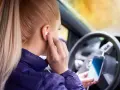 Ragazza in auto inserisce auricolari, pronta per ascoltare musica o chiamare. Come togliere la e sul cellulare? Forse sta cercando un modo per disattivare le notifiche.