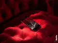 Telefono con schermo rotto su un divano rosso. Non riesco a spegnere il telefono, è bloccato.