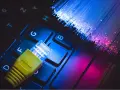 Connessione internet: un cavo giallo su tastiera e fibre ottiche luminose. Capire cos'è l'ADSL è fondamentale per la tua navigazione.