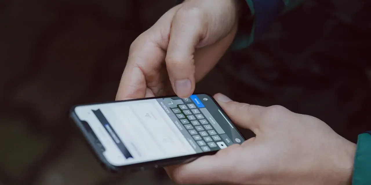 Mani che digitano su uno smartphone, mostrando la tastiera. Capire a cosa servono i giga è fondamentale per navigare, chattare e condividere.