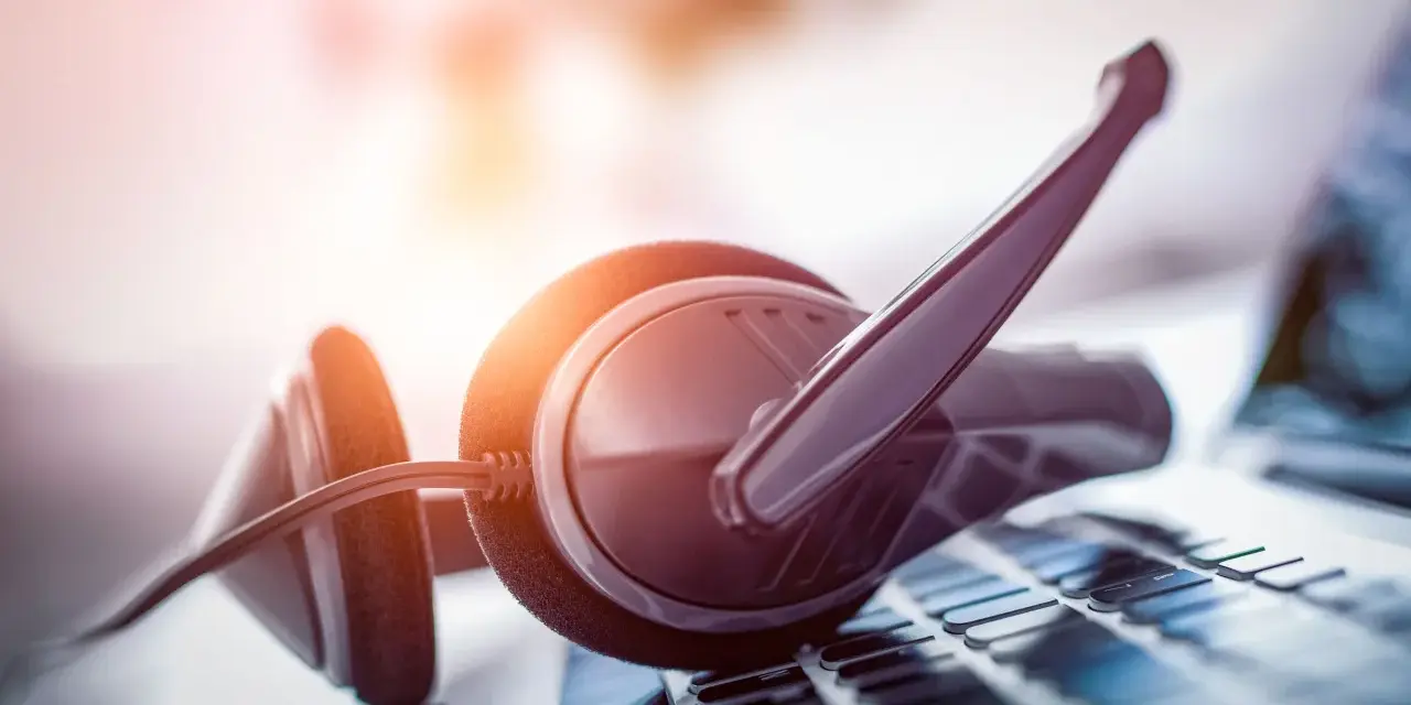 Cuffie con microfono su tastiera. Per sapere come parlare con un operatore Fastweb non cliente, cerca online o contatta i canali dedicati.