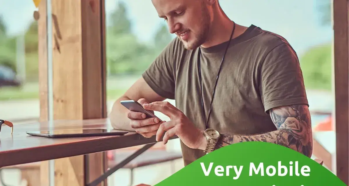 Uomo con tatuaggi guarda il suo smartphone, leggendo le very opinioni su "Very Mobile Recensioni".