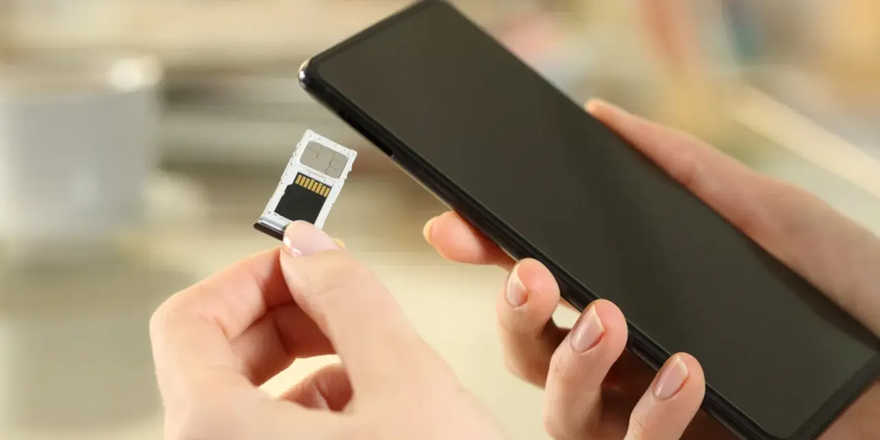 Mani che inseriscono una SIM in uno smartphone, forse per evitare gli svantaggi dual SIM.