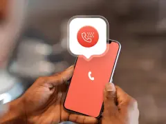 Mani che tengono uno smartphone con un'icona di chiamata e un fumetto. Impara come bloccare un numero privato per la tua tranquillità.