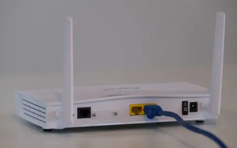 Router bianco con antenne, cavo blu collegato. Soluzione per internet a casa senza fibra.