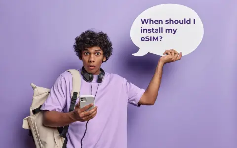 Ragazzo con zaino e cuffie, perplesso, tiene in mano un telefono e una nuvoletta con scritto "When should I install my eSIM?". Attivazione immediata!