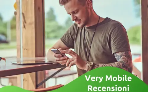 Uomo con tatuaggi guarda il suo smartphone, leggendo le very opinioni su "Very Mobile Recensioni".