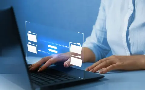 Mani su tastiera laptop, interfaccia digitale con icone di cartelle e frecce che indicano il trasferimento dati, utile per capire come inviare video pesanti.