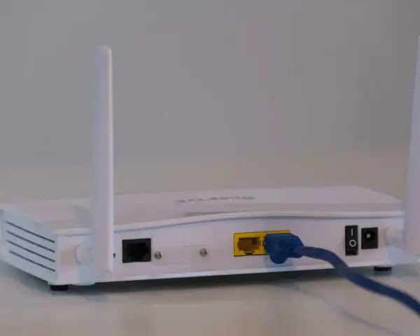Router bianco con antenne, cavo blu collegato. Soluzione per internet a casa senza fibra.