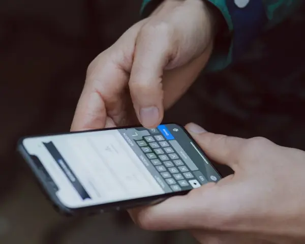 Mani che digitano su uno smartphone, mostrando la tastiera. Capire a cosa servono i giga è fondamentale per navigare, chattare e condividere.