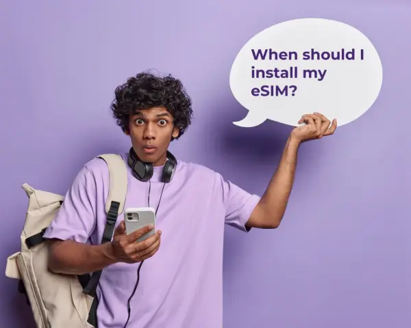 Ragazzo con zaino e cuffie, perplesso, tiene in mano un telefono e una nuvoletta con scritto "When should I install my eSIM?". Attivazione immediata!