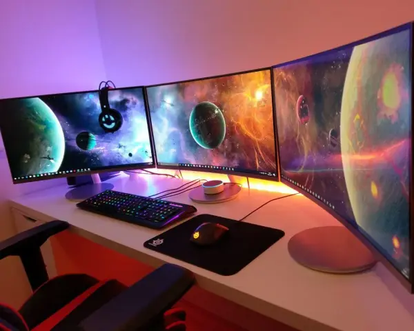 Postazione gaming con tre monitor curvi che mostrano pianeti spaziali. La tastiera e il mouse sono illuminati, pronti per ruotare schermo pc e immergersi nell'avventura.