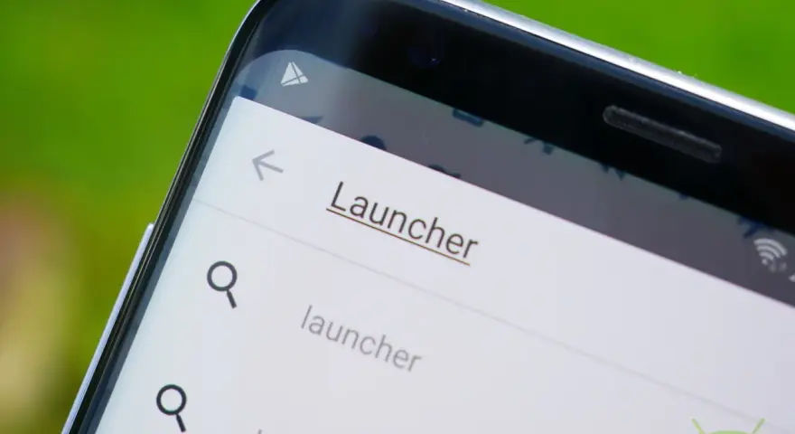 Schermata di un telefono con la parola "Launcher" in evidenza, suggerendo la ricerca di un nuovo launcher di sistema.