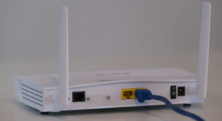 Router bianco con antenne, cavo blu collegato. Soluzione per internet a casa senza fibra.