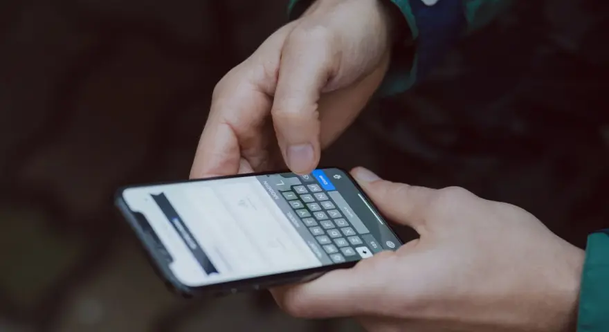 Mani che digitano su uno smartphone, mostrando la tastiera. Capire a cosa servono i giga è fondamentale per navigare, chattare e condividere.