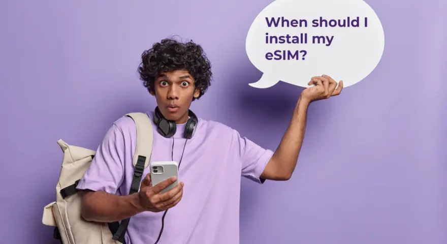 Ragazzo con zaino e cuffie, perplesso, tiene in mano un telefono e una nuvoletta con scritto "When should I install my eSIM?". Attivazione immediata!