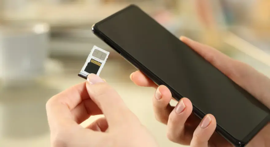 Mani che inseriscono una SIM in uno smartphone, forse per evitare gli svantaggi dual SIM.