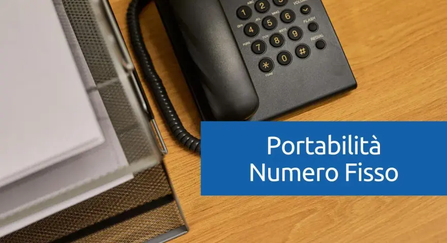 Telefono fisso e documenti su scrivania in legno. Testo: "Portabilità Numero Fisso".