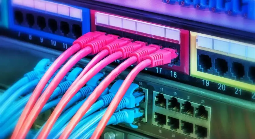 Cavi di rete colorati collegati a un pannello, pronti per il cambio operatore internet casa.