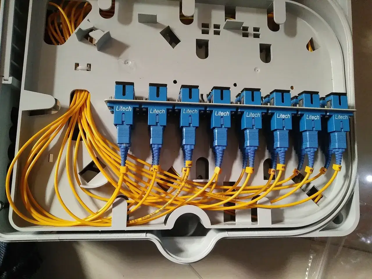 Scatola di derivazione per fibra fttc con cavi gialli e connettori blu Litech.
