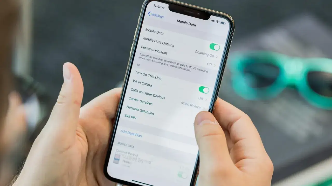 Mani che tengono uno smartphone con impostazioni dati mobili attive. Possibili svantaggi dual SIM: gestione dati e roaming.