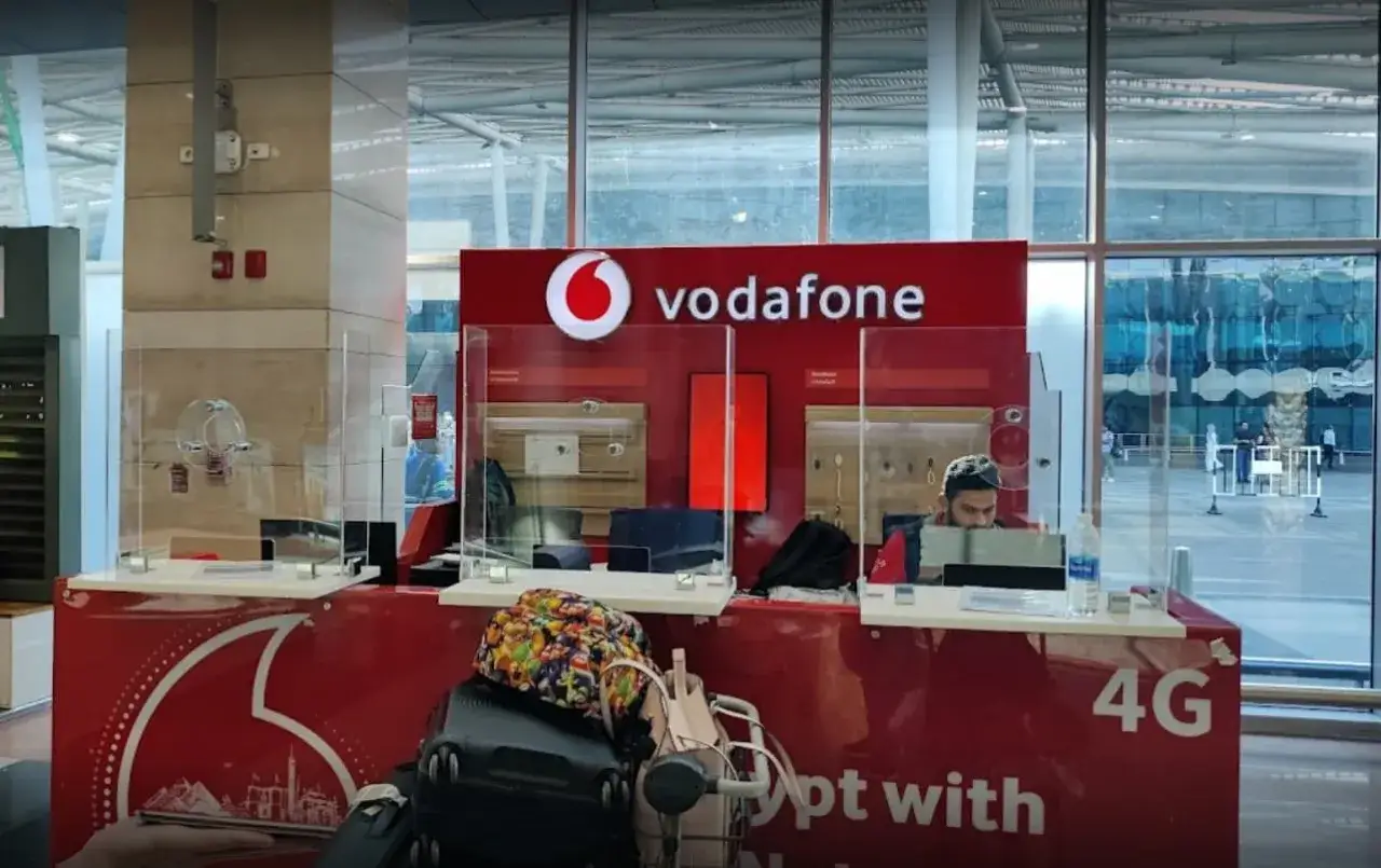 Chiosco Vodafone Egitto con bagagli in attesa.