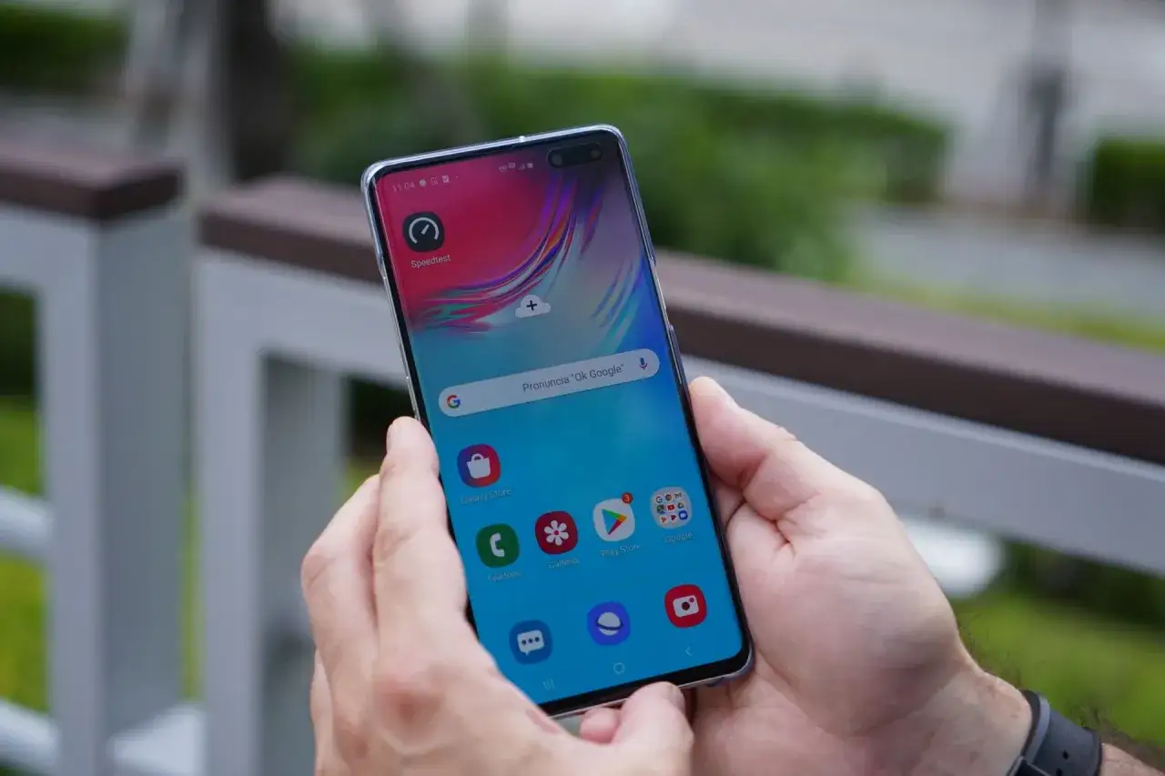 Mani che tengono uno smartphone con l'app Speedtest aperta, per verificare la connessione dati.