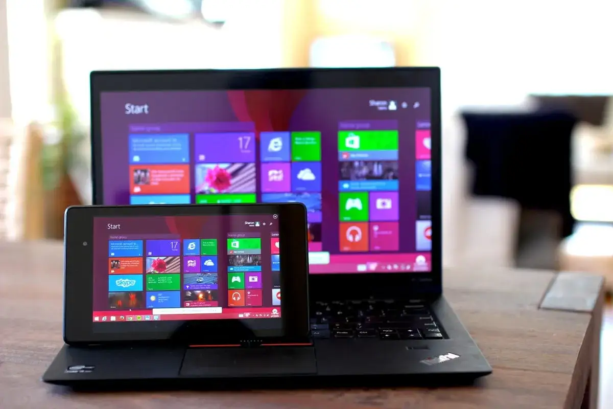 Un tablet con interfaccia simile a Windows &egrave; posizionato su un laptop. L'android su pc mostra un'interfaccia moderna.