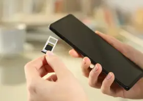 Mani che inseriscono una SIM in uno smartphone, forse per evitare gli svantaggi dual SIM.