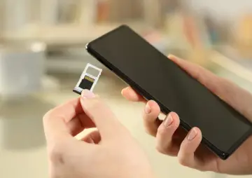 Mani che inseriscono una SIM in uno smartphone, forse per evitare gli svantaggi dual SIM.